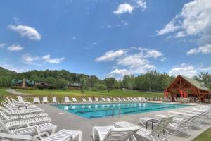 una piscina con tumbonas y un granero en Luxury Endless View 3 King Suites Billards Pool, en Sevierville