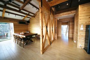 une salle à manger avec une table et des murs en bois dans l'établissement ビーチキャビン - シービュー バーベキュー ピザ サウナ プール ホットタブ - Beach Cabin Chiba - Seaview BBQ Pizza Sauna Pool Hot-tub, à Kobama