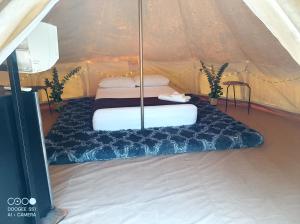 a bed in a canvas tent with a mattress at Cozumel Glamping in Cozumel