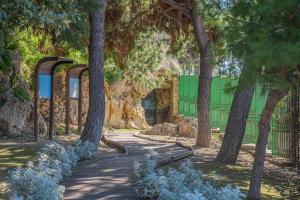 a path in front of a green building with trees at Casa Fadda in Cagliari +7 photos