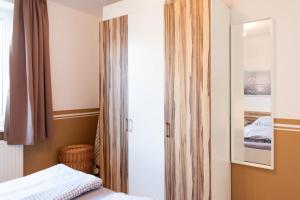- une chambre avec un placard, un lit et un miroir dans l'établissement Ferienwohnung MehrBlick 22, à Niendorf