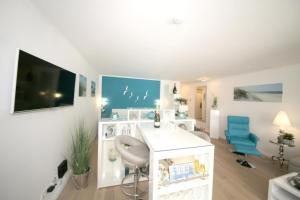 salon z białym biurkiem i niebieskimi krzesłami w obiekcie Ferienwohnung Strandallee 200 w mieście Timmendorfer Strand