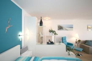 biały pokój z łóżkiem i kanapą w obiekcie Ferienwohnung Strandallee 200 w mieście Timmendorfer Strand