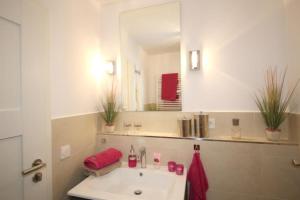 łazienka z umywalką i lustrem w obiekcie Ferienwohnung Strandallee 200 w mieście Timmendorfer Strand +17 zdjęć