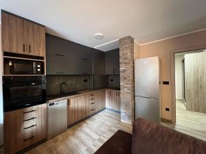 eine Küche mit Holzschränken und Geräten aus Edelstahl in der Unterkunft Apartman Dašić in Jagodina + 11 Fotos