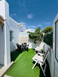 a patio with lawn chairs and tables on a balcony at Bungalow Vista Dunas 32 in San Bartolomé de Tirajana +38 photos