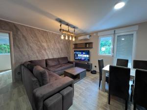 ein Wohnzimmer mit einer Couch und einem Tisch in der Unterkunft Apartman Dašić in Jagodina