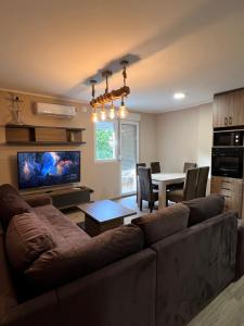 Una sala de estar con un sofá y un comedor. en Apartman Dašić, en Jagodina