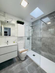 a bathroom with a toilet and a glass shower at Bungalow Vista Dunas 32 in San Bartolomé de Tirajana