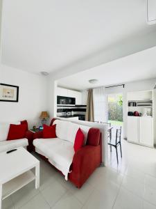 a living room with a red and white couch at Bungalow Vista Dunas 32 in San Bartolomé de Tirajana