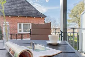a table with a book and a cup of coffee on a balcony at Ferienwohnung Stern 3 Scharbeutz in Scharbeutz