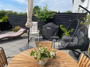 奈斯特韦兹Velindrettet rækkehus med fantastisk udsigt的带桌椅和遮阳伞的露台