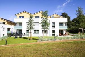 a large white building with a yard in front of it at Ferienwohnung Dünenhäuser App. A2 in Scharbeutz