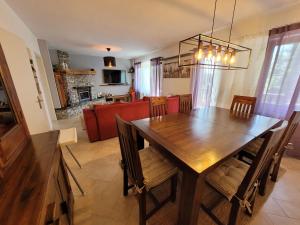 a dining room and living room with a wooden table and chairs at Holiday house SuPer in Slunj