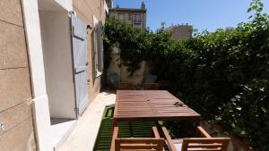 una mesa de madera y sillas junto a un edificio en Le Grand Bleu, en Marsella