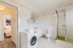 a bathroom with a washing machine and a toilet at Ferienwohnung 2 Haus Meeresrauschen in Haffkrug +31 photos
