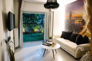 een woonkamer met een bank en een tafel bij La Martina Glam Residence - 15 Airport Macedonia in Trílofon