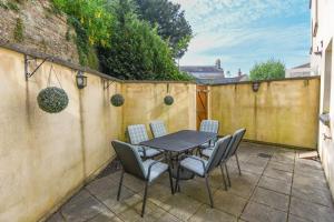 a patio with a table and chairs and a fence at Spacious Townhouse Private Parking Central Wells in Wells
