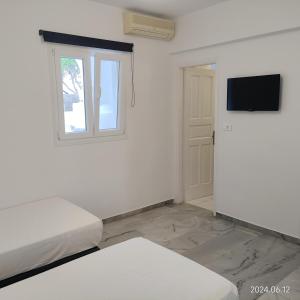 Habitación blanca con cama y ventana en Villa Irini en Náousa