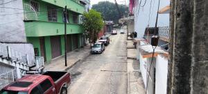 a street with cars parked on the side of a building at Hotel Casa Luna in Palenque