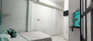 a white room with a bed and a window at Hotel Casa Luna in Palenque