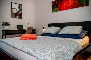 a bedroom with a bed with an orange towel on it at Apartments Częstochowa - Słoneczna Kamienica - Centrum - Prywatny Parking free! - Klimatyzacja ! in Częstochowa