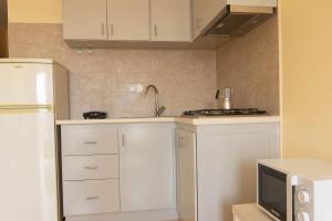 a kitchen with white cabinets and a white refrigerator at Beauty Plaza Apartaments in Santa Maria