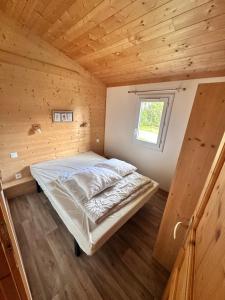 a bed in a small room with a window at Chalet 45m2 in Mios