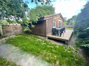 a small cabin with a table and chairs on a deck at Chalet 45m2 in Mios