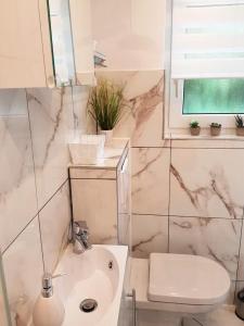 a white bathroom with a sink and a toilet at Ferienhaus Ellie in Haffkrug +18 photos