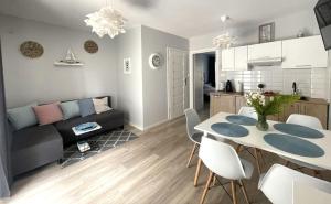a living room and kitchen with a table and chairs at Apartamenty Przy Wydmie in Rowy