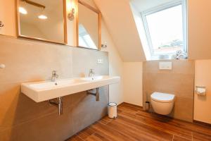 a bathroom with a sink and a toilet at Ferienhaus NORTH COAST in Scharbeutz +48 photos