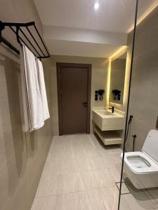un bagno con lavandino, WC e specchio di فندق اللحظات السعيدة a Riyad