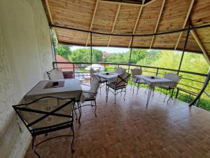 a room with tables and chairs on a balcony at Stars Palić in Palić