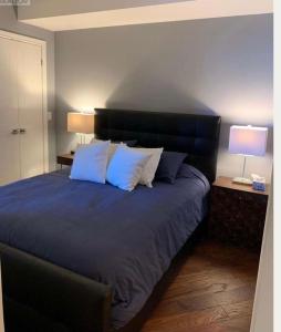 a bedroom with a large bed with blue sheets and pillows at Million Dollar Lake-view - Spacious 2 bedroom- 2 bathroom Condo across the lake with stunning lake view in Toronto