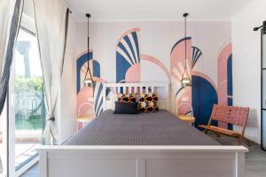 a bedroom with a bed with a mural on the wall at Luxury Casa Madeira, HEATED Salt Water Pool and Panoramic Woodfire Sauna in Lagos +37 photos