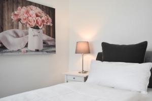 a bedroom with a bed with a vase of pink roses at Ferienwohnung Küstentraum 2 in Travemünde