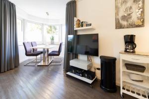 沙博伊茨Ferienwohnung Kleine Auszeit的配有电视和桌椅的客厅