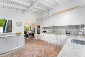 a kitchen with white cabinets and a dining room at Luxury Casa Madeira, HEATED Salt Water Pool and Panoramic Woodfire Sauna in Lagos