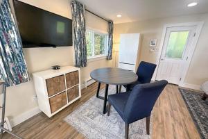 a living room with a table and chairs and a tv at Ocean Front, Cottage at Oregon House, Stairs to the Beach! in Searose Beach
