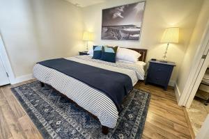 a bedroom with a large bed with blue and white sheets at Ocean Front, Cottage at Oregon House, Stairs to the Beach! in Searose Beach