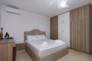 ein Schlafzimmer mit einem großen Bett und Holzschränken in der Unterkunft Villa Valentino Swimming Pool in Moravë