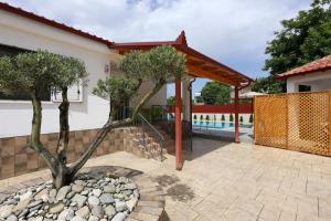 eine Terrasse mit Bäumen und einem Zaun und einem Pool in der Unterkunft Villa Valentino Swimming Pool in Moravë