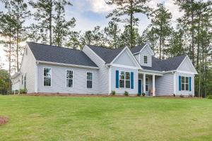 a white house with blue accents on a yard at Savannah Lakes Village Home Golf and Hike! in McCormick