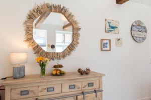 un miroir au-dessus d'une commode dans une pièce dans l'établissement Ferienwohnung Nordic Nature Loft in Travemünde direkt in der Vorderreihe inkl Privatsauna, à Travemünde