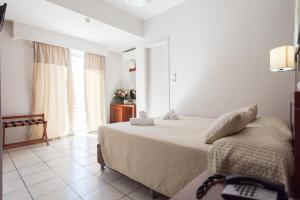 a bedroom with a bed and a phone on a table at Epidavros Hotel in Athens