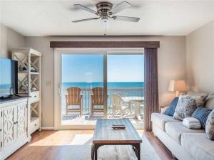 a living room with a couch and a view of the ocean at Ocean Dunes 2112 in Kure Beach