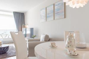 ティメンドルファー・シュトラントにあるFerienwohnung Residenz App. 911の白いリビングルーム(白いテーブル、椅子付)