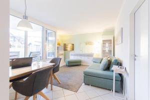 a living room with a blue couch and a table at Ferienwohnung Urlaubsflair in Timmendorfer Strand