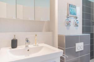 a white bathroom with a sink and a mirror at Ferienwohnung Urlaubsflair in Timmendorfer Strand